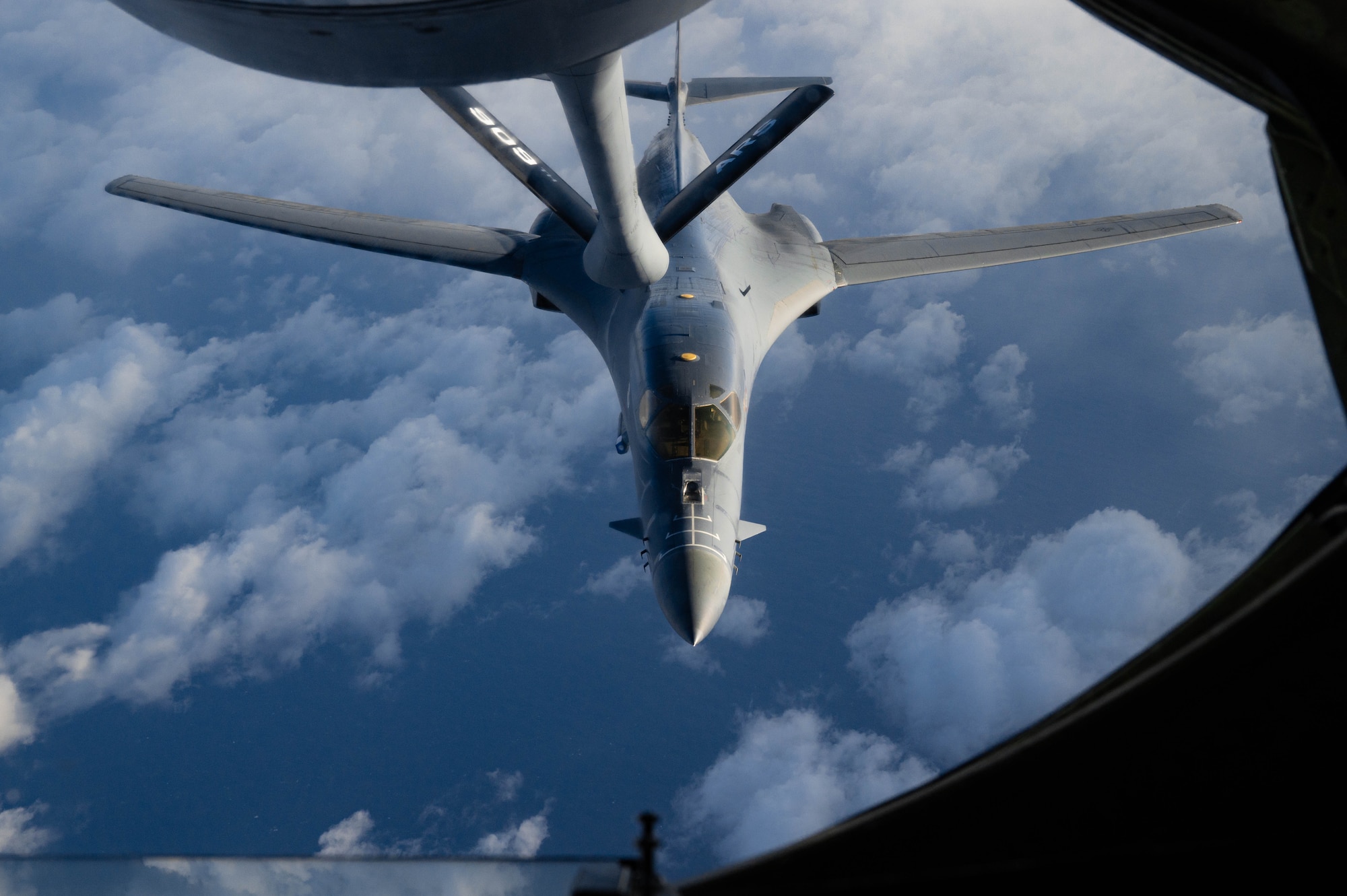 A bomber approaches a boom to conduct aerial refueling.