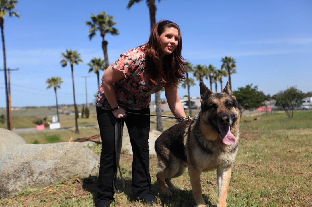 Former Cpl. Megan Leavey pets Military Working Dog Rex during his retirement ceremony and adoption at Camp Pendleton's K-9 unit, April 6. Leavey, who was previously Rex's handler, had written a letter to Congress requesting to adopt Rex since he was being forced to retire due to facial paralysis. Rex served in three combat deployments and provided over 11,575 hours of military working dog support consisting of over 6,220 vehicle inspections during random anti-terrorism searches. Rex was constantly put in harm's way during multiple firefights, mortar attacks and improvised explosive devices during Operation Iraqi Freedom.