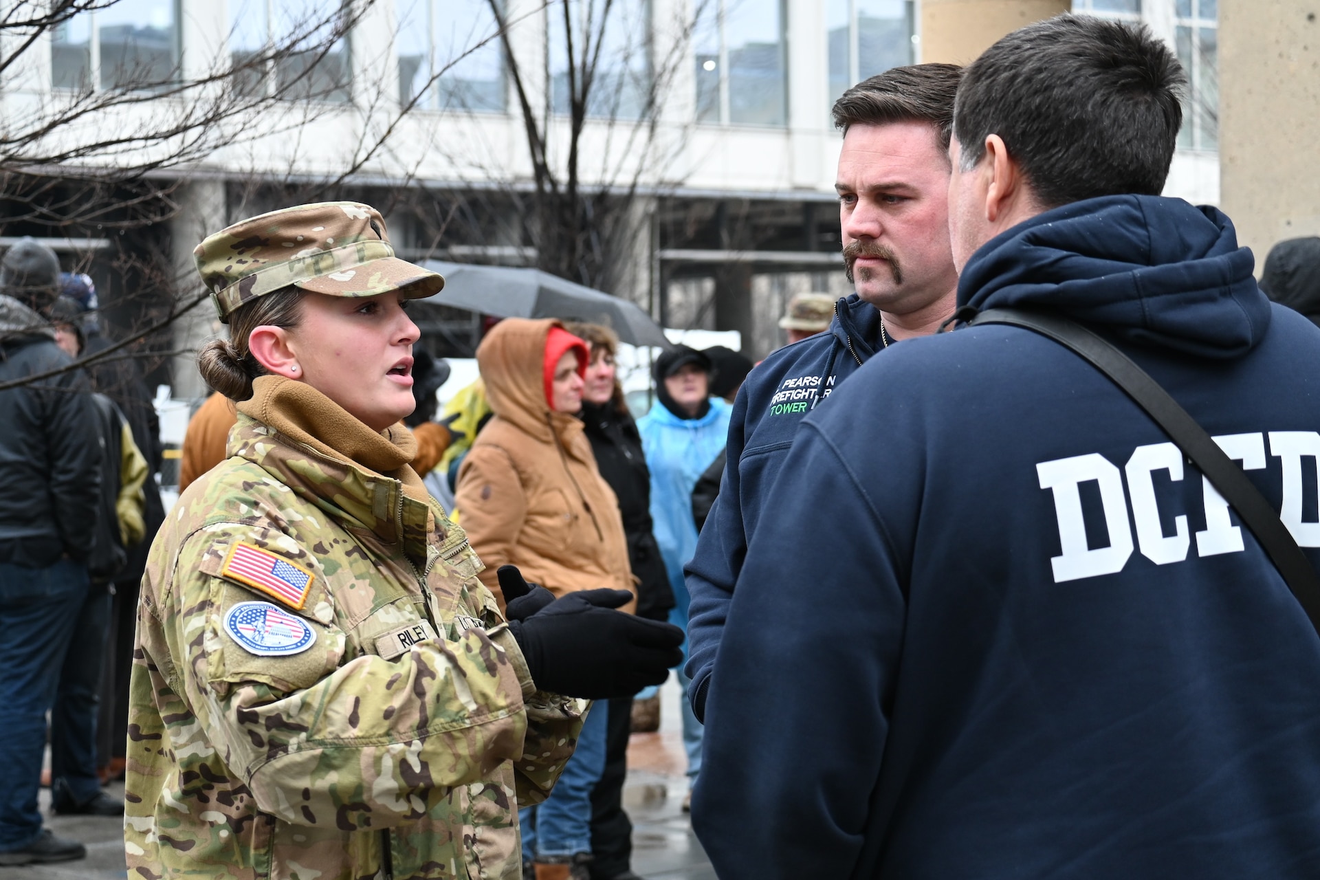 U.S. Army Spc. Jolene Riley, assigned to the 1069th Military Police Company, 55th Maneuver Enhancement Brigade, Pennsylvania Army National Guard, coordinates with D.C. firefighters during Joint Task Force-District of Columbia's (JTF-DC) support of the 60th Presidential Inauguration Jan. 19, 2025. Approximately 8,000 National Guard service members from approximately 40 states and territories comprise JTF-DC to support the 60th Presidential Inauguration, continuing a legacy that began in 1789 when their predecessors escorted George Washington to the first inauguration. At the request of civil authorities, these National Guard service members provide critical support such as crowd management, traffic control points, CBRN response, civil disturbance response and sustainment operations. Their expertise and seamless collaboration with interagency partners help ensure a safe and peaceful transition of power during this historic event. (U.S. Army National Guard photo by Sgt. 1st Class Shane Smith)