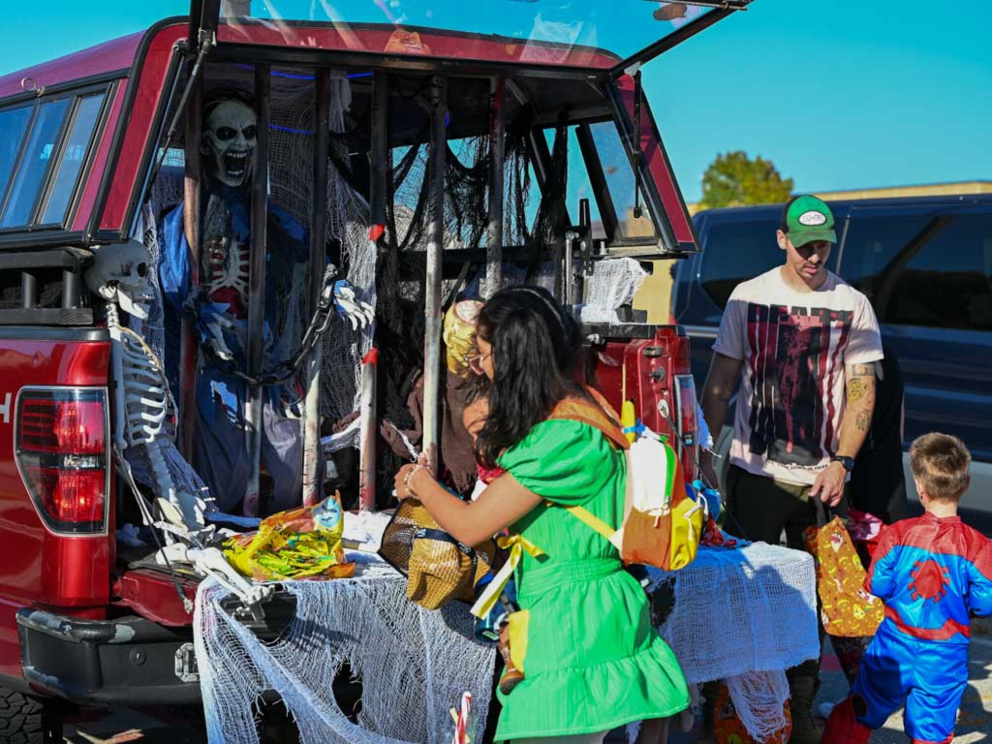 Trick-or-treaters visit a haunted jail-themed Trunk-or-Treat station during the 552nd Air Control Wing’s Boo Bash at Tinker Air Force Base. The elaborate setup brought spooky fun to families and added to the festive Halloween atmosphere.
(U.S. Air Force photo by Garrett N. Cole)