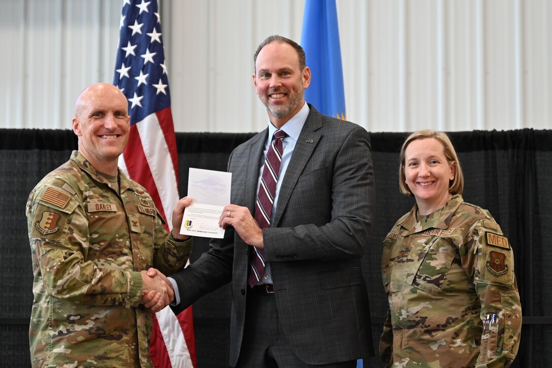 Dr. Brad Archer, center, of Monument Health is welcomed by Col. Derek Oakley, 28th Bomb Wing commander, after his selection as an Ellsworth Air Force Base honorary commander, January 14, 2025 at the Liberty Center, Box Elder, S.D.
