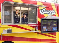 Cook and driver Brando Jativa and server Elizabeth Ritalo await their next customer inside the "Sauced" food truck Nov. 13, 2024, at Naval Base Kitsap-Bangor, Silverdale, Washington. The food truck specializes in Filipino, Hawaiian and Mexican cuisine. (U.S. Navy photo by Wendy Hallmark)