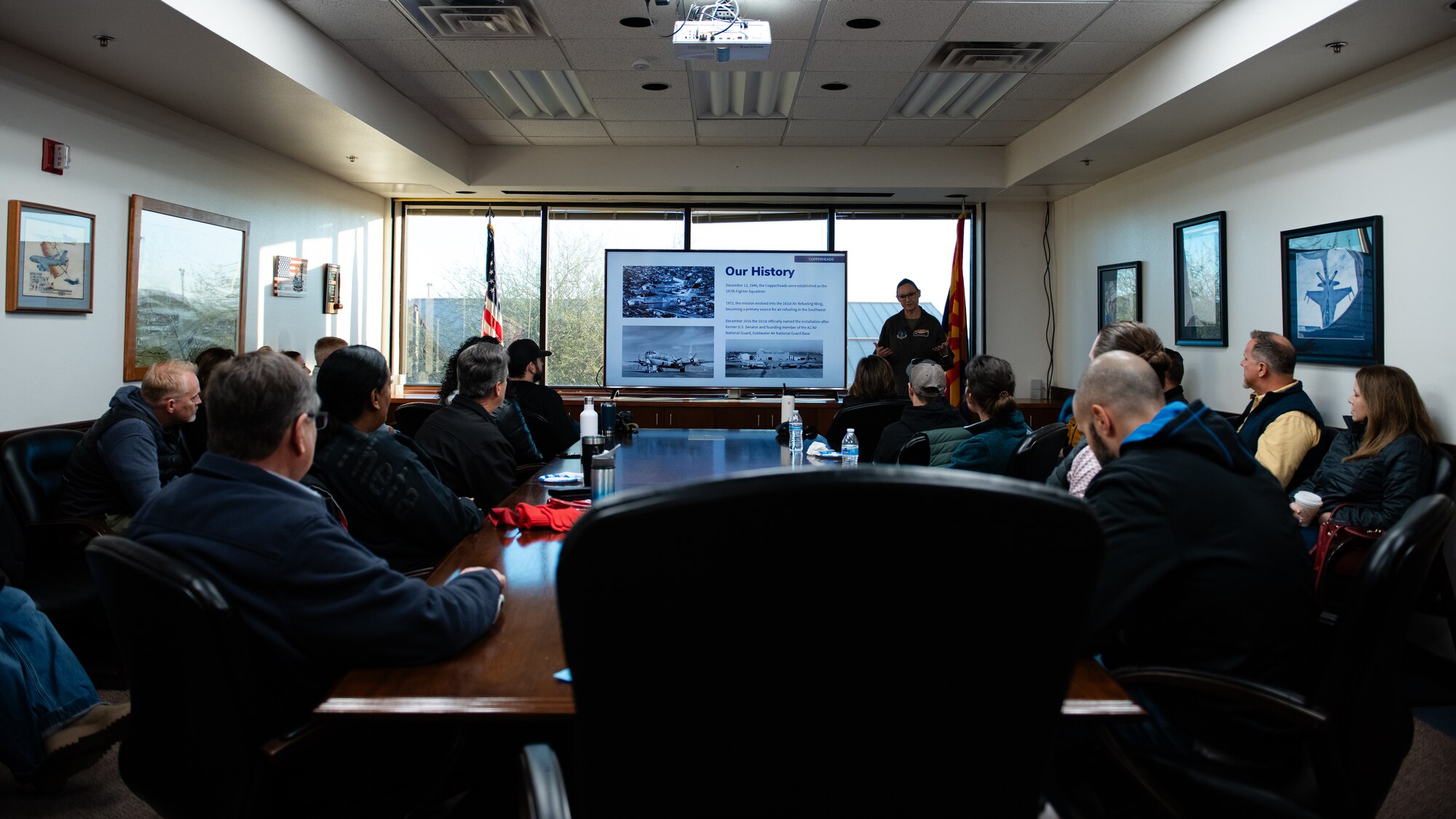 U.S. Air Force Col. Jessica Hastings, 161st Air Refueling Wing commander, briefs 56th Fighter Wing honorary commanders on the history of their unit and the U.S. Air Force KC-135 Stratotanker.