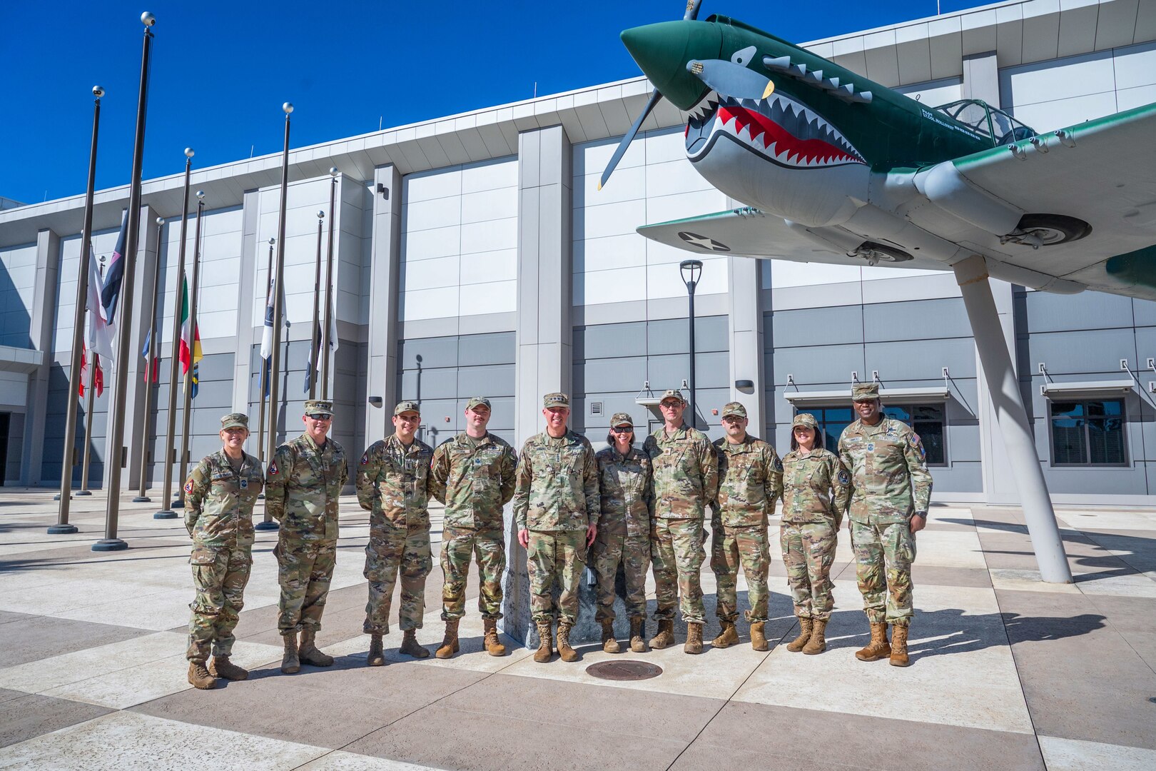 A group of military members stand together for a group photo.