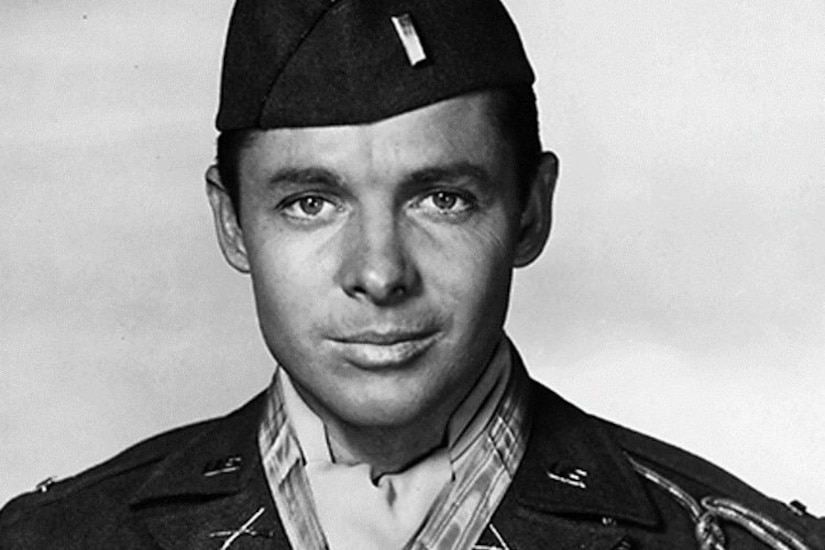 A man in a uniform and cap poses for a photo.