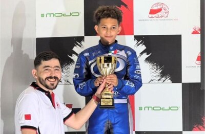 Young boy award trophy during motorsport event.