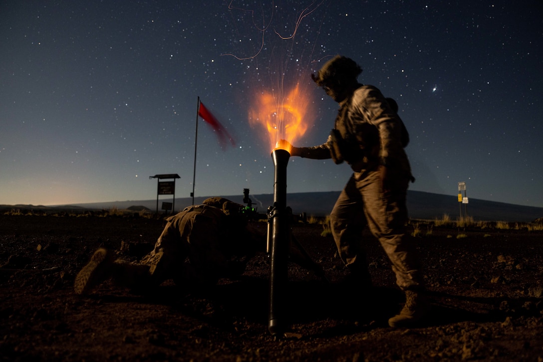 Marine Corps Sgt. Michael Rivera, right, and Pfc. Joshua Guzman fire an M252A2 81 mm mortar system during a training exercise at Pohakuloa Training Area, Hawaii, Jan. 17, 2025.