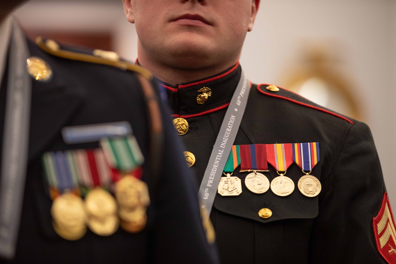 A Marine stands while wearing decorative military attire of medals.