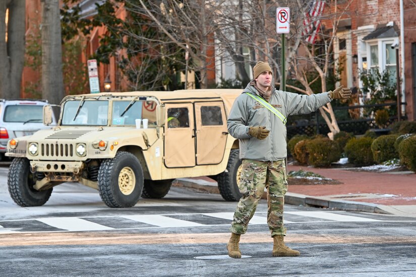 U.S. Air Force Airman 1st Class Samuel Mayhoff, a member of the 193rd Special Operations Wing, Pennsylvania Air National Guard, attached to Joint Task Force-District of Columbia (JTF-DC), directs traffic in the Capitol Hill area, Jan. 20, 2025. Approximately 8,000 National Guard service members from approximately 40 states and territories comprise JTF-DC to support the 60th Presidential Inauguration, continuing a legacy that began in 1789 when their predecessors escorted George Washington to the first inauguration. At the request of civil authorities, these National Guard service members provide critical support such as crowd management, traffic control points, CBRN response, civil disturbance response and sustainment operations. Their expertise and seamless collaboration with interagency partners help ensure a safe and peaceful transition of power during this historic event. (U.S. Air National Guard photo by Tech. Sgt. Andrew Enriquez)