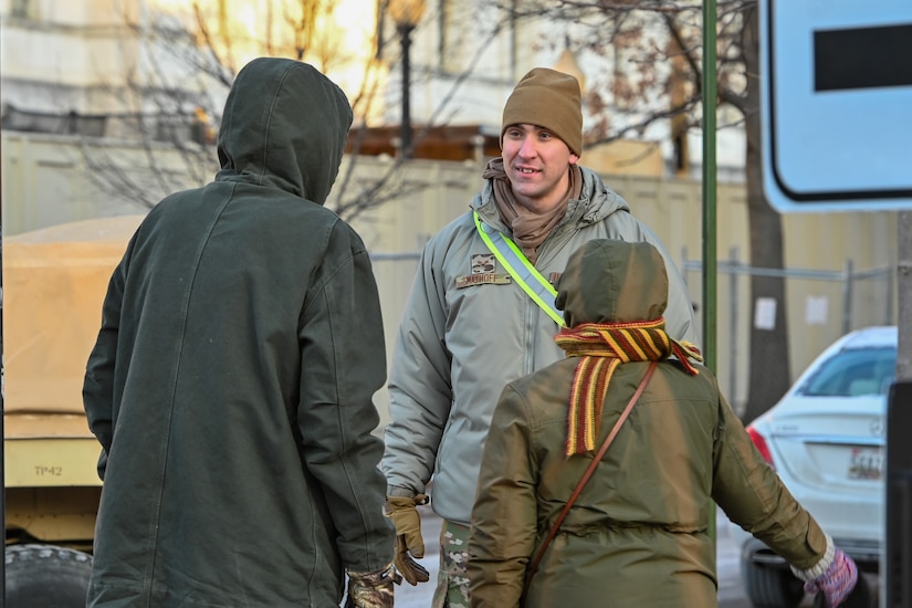 U.S. Air Force Airman 1st Class Samuel Mayhoff, a member of the 193rd Special Operations Wing, Pennsylvania Air National Guard, attached to Joint Task Force-District of Columbia (JTF-DC), speaks with pedestrians while providing traffic control in support of the 60th Presidential Inauguration, in Washington, D.C., Jan. 20, 2025. Approximately 8,000 National Guard service members from approximately 40 states and territories comprise JTF-DC to support the 60th Presidential Inauguration, continuing a legacy that began in 1789 when their predecessors escorted George Washington to the first inauguration. At the request of civil authorities, these National Guard service members provide critical support such as crowd management, traffic control points, CBRN response, civil disturbance response and sustainment operations. Their expertise and seamless collaboration with interagency partners help ensure a safe and peaceful transition of power during this historic event. (U.S. Air National Guard photo by Tech. Sgt. Andrew Enriquez)