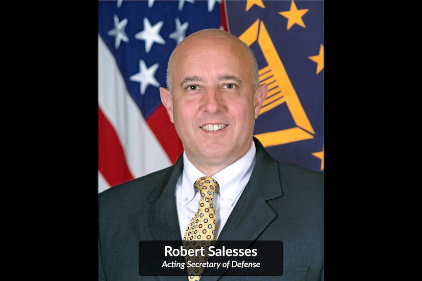 A man poses for a photo in front of an American flag.