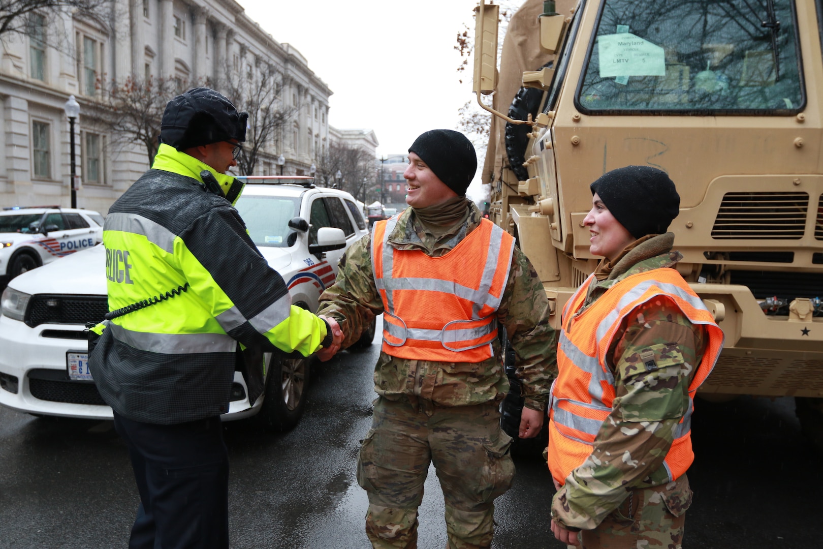 U.S. Army Spc. Kane Lesoine, a motor transport operator assigned to the 121st Transportation Company, 213th Regional Support Group, Pennsylvania Army National Guard, shakes hands with a D.C. Metropolitan Police Department official while providing traffic control in Washington, D.C. as part of Joint Task Force-District of Columbia in support of the 60th Presidential Inauguration, Jan. 19, 2025. Approximately 8,000 National Guard service members from approximately 40 states and territories comprise JTF-DC to support the 60th Presidential Inauguration, continuing a legacy that began in 1789 when their predecessors escorted George Washington to the first inauguration. At the request of civil authorities, these National Guard service members provide critical support such as crowd management, traffic control points, CBRN response, civil disturbance response and sustainment operations. Their expertise and seamless collaboration with interagency partners help ensure a safe and peaceful transition of power during this historic event.