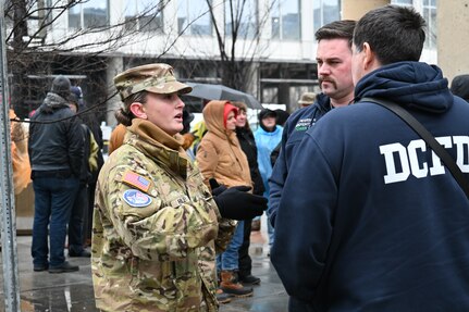 .S. Army Spc. Jolene Riley, assigned to the 1069th Military Police Company, 55th Maneuver Enhancement Brigade, Pennsylvania Army National Guard, coordinates with D.C. firefighters during Joint Task Force-District of Columbia's (JTF-DC) support of the 60th Presidential Inauguration Jan. 19, 2025. Approximately 8,000 National Guard service members from approximately 40 states and territories comprise JTF-DC to support the 60th Presidential Inauguration, continuing a legacy that began in 1789 when their predecessors escorted George Washington to the first inauguration. At the request of civil authorities, these National Guard service members provide critical support such as crowd management, traffic control points, CBRN response, civil disturbance response and sustainment operations. Their expertise and seamless collaboration with interagency partners help ensure a safe and peaceful transition of power during this historic event.