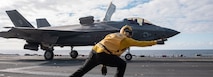 Aviation Boatswain’s Mate (Handling) 2nd Class Edward Stewart, from Suffolk, Virginia, assigned to the forward-deployed amphibious assault ship USS America (LHA 6), launches an F-35B Lightning II fighter aircraft from Marine Fighter Attack Squadron (VMFA) 242 on the ship’s flight deck in the Philippine Sea, Jan. 20.