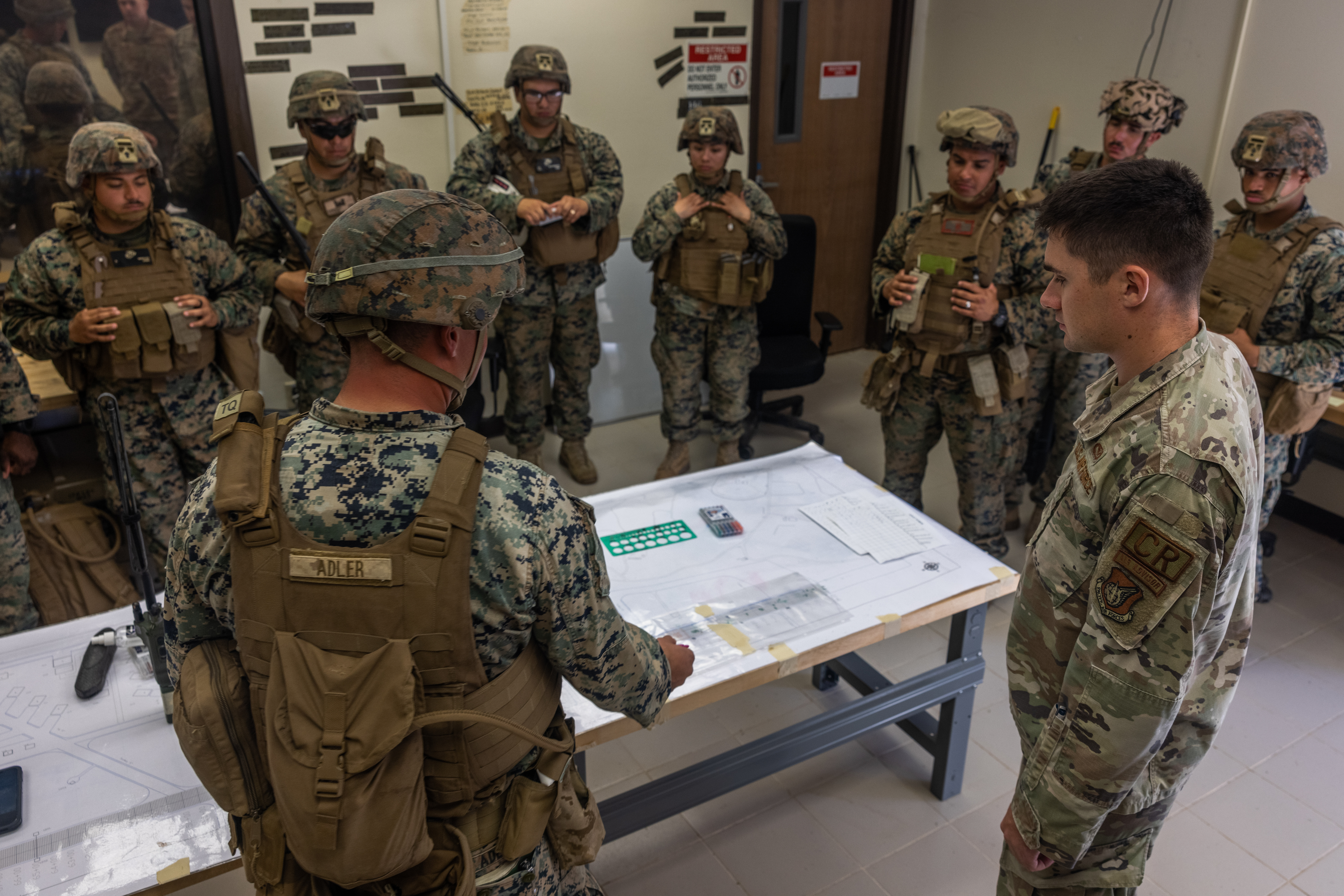 U.S. Marine Corps Capt. Zachary Adler, an engineer company commander with Marine Wing Support Squadron 373, Marine Aircraft Group 38, 3rd Marine Air Wing, briefs U.S. Air Force Capt. Celyn Rogers, an officer with the 554th Rapid Engineer Deployable Heavy Operations Repair Squadron, during an airfield damage recovery and fire rescue exchange as part of exercise Silver Flag on Andersen Air Force Base, Guam, Jan. 10, 2025. The exercise provided MWSS-373 Marines with an opportunity to train alongside sister services and partner nations in expeditionary airfield damage repair and base recovery operations. (U.S. Marine Corps photo by Cpl. Ryan Little)