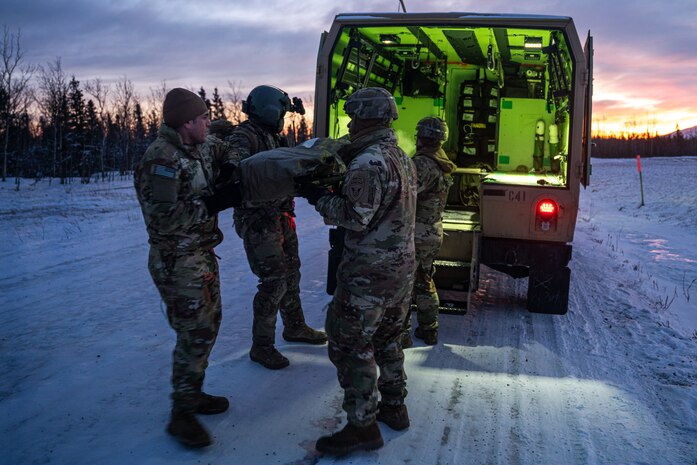 Soldiers assigned to Charlie Company, 25th Brigade Support Battalion, 1st Infantry Brigade Combat Team, 11th Airborne Division, move a simulated casualty into a Field Litter Ambulance as part of a medical evacuation rehearsal ahead of Joint Pacific Multinational Readiness Center 25-02, at the Donnelly Training Area near Fort Greely, Alaska, Jan. 18, 2025.