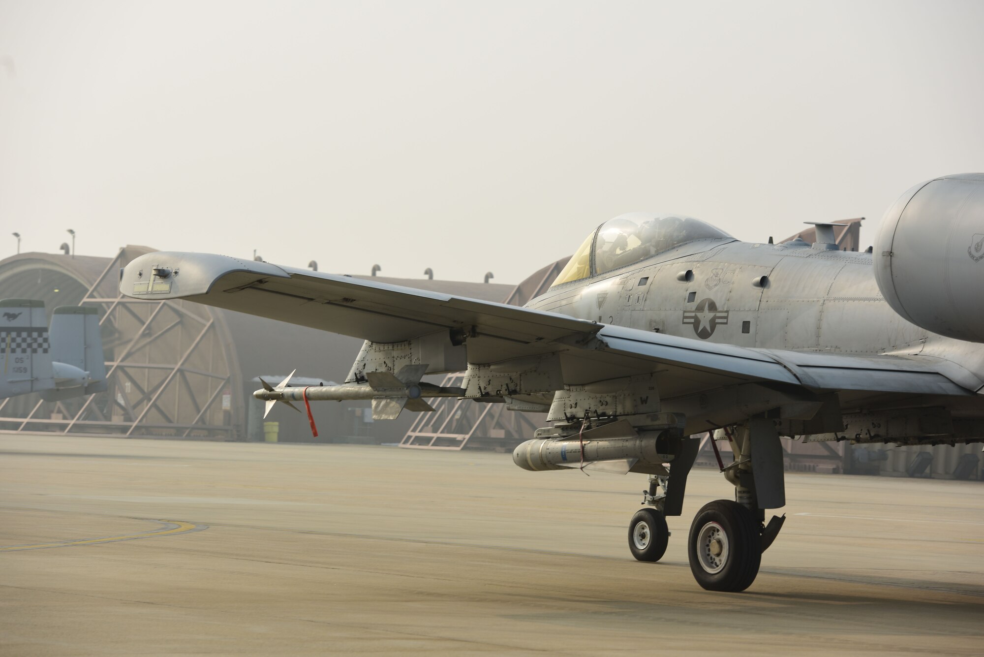 A U.S. Air Force A-10 Thunderbolt II pilot assigned to the 25th Fighter Squadron taxis away from a hangar, at Osan Air Base