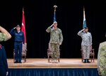 Turkish navy Rear Adm. Rüştü Sezer, Vice Adm. George Wikoff, and Pakistan navy Commodore Sohail Azmie render honors during a change-of-command ceremony in Manama, Bahrain.