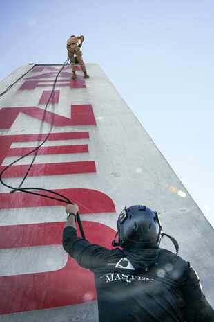 A U.S. Marine Corps helicopter rope suspension techniques master, with Support Battalion, Recruit Training Regiment, belay a Marine on the rappel tower at Marine Corps Recruit Depot San Diego, California, Jan. 10, 2025. The rappel tower provides opportunities for the new Marines to gain confidence in themselves and their gear and is one of the last training events Marines will conduct while at MCRD San Diego. Most ready when our nation is least ready, we train Marines to defeat the challengers, obstacles, and potential adversaries that hinder our nation’s progress and threaten our peace and security. (U.S. Marine Corps photo by Cpl. Sarah M. Grawcock)
