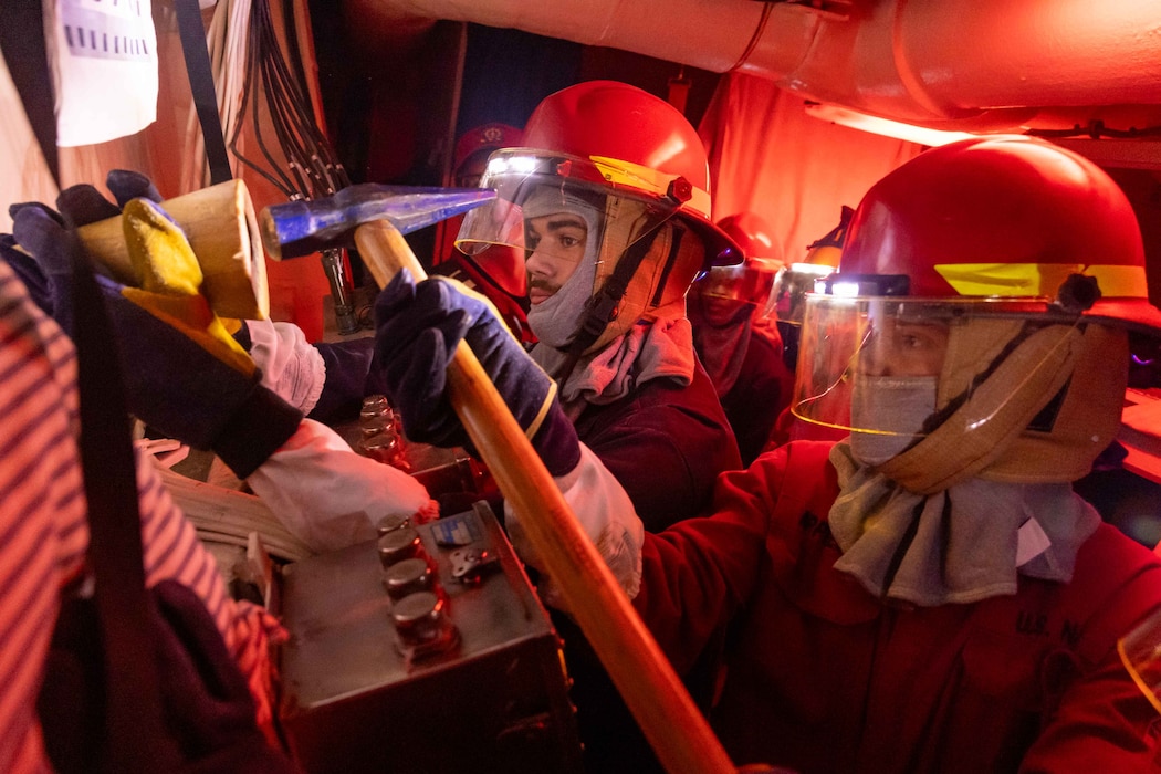 Sailors plug a simulated hole during a structural damage drill aboard USS Preble (DDG 88) in the Philippine Sea.