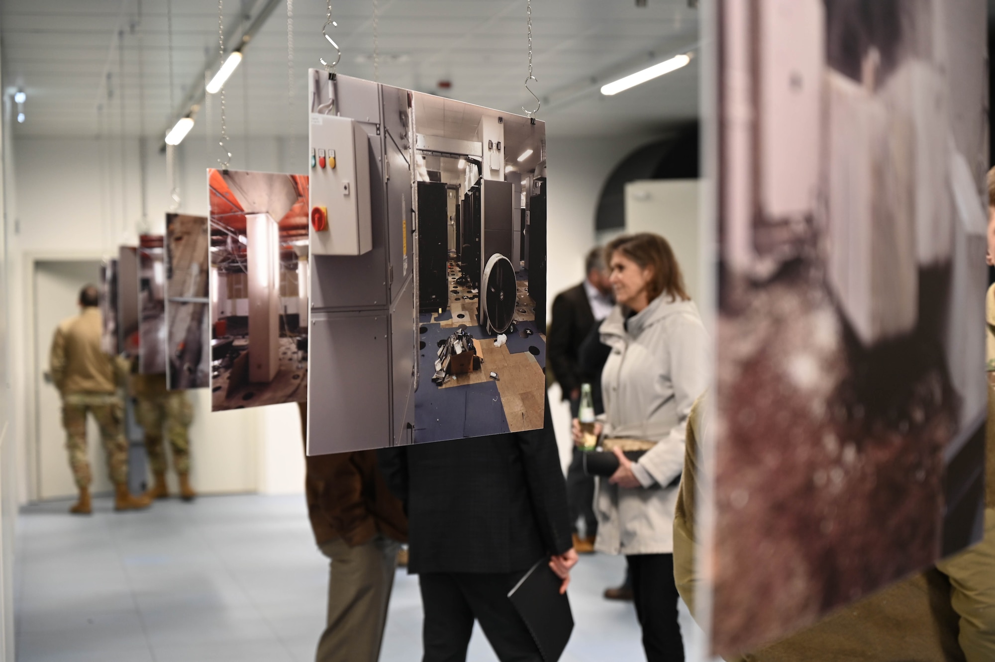 Photos of different stages of building renovations hang from the ceiling