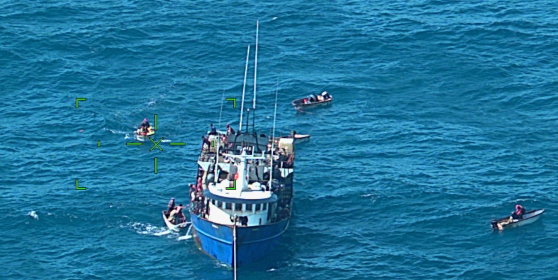 The fishing vessel Bonanza surrounded by smaller vessels during the rescue of four U.S. boaters from a life raft in Atlantic Ocean waters north of Dominican Republic, Jan. 21, 2025. The survivors were forced to abandon the sailing vessel Mariposa after it sank moments earlier in Atlantic Ocean waters north of Dominican Republic.  The survivors were rescued by fishermen with the assistance of a Coast Guard aircrew, and transferred to the U.S. flagged container ship Coqui for their transport to Jacksonville, Fla. (U.S. Coast Guard photo)