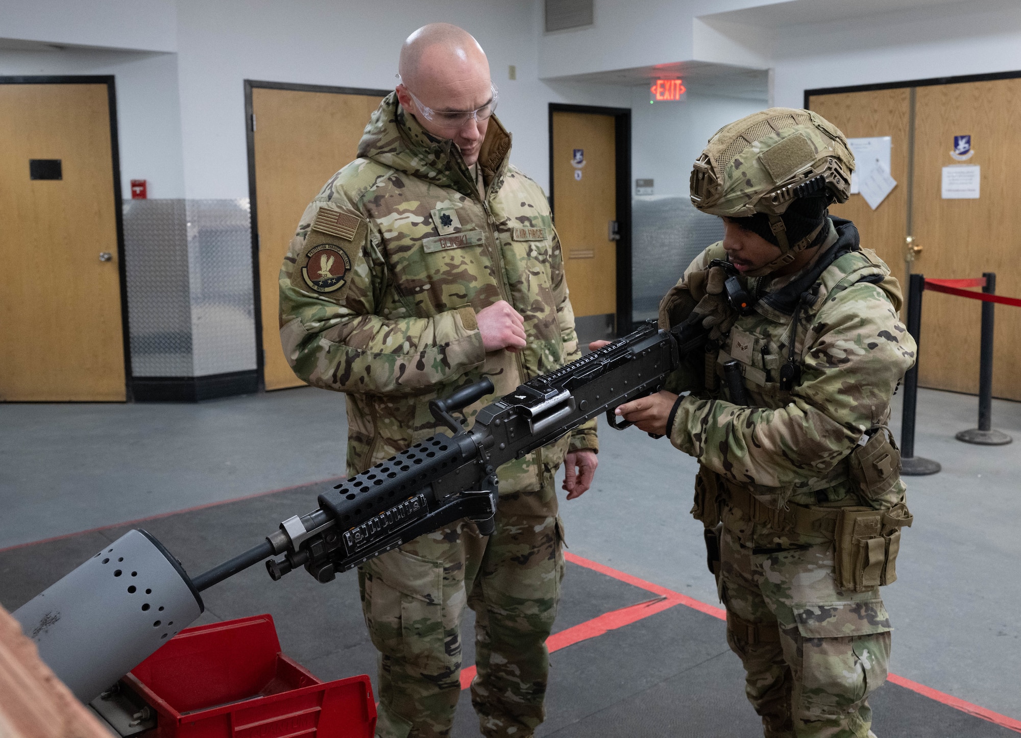 Airman 1st Class Rathana Pich, the 91st Missile Security Forces Squadron (91MSFS) Defender, performs clearing procedures for a M240B machine gun with supervision from U.S. Air Force Lt. Col. Harlan Glinski, assigned to the 91MSFS, at Minot Air Force Base, North Dakota, Jan. 14, 2025. Airmen were issued gear and driven to a Missile Alert Facility (MAF) to simulate the assault of a MAF. (U.S. Air Force photo by Airman 1st Class Wesley Davies)