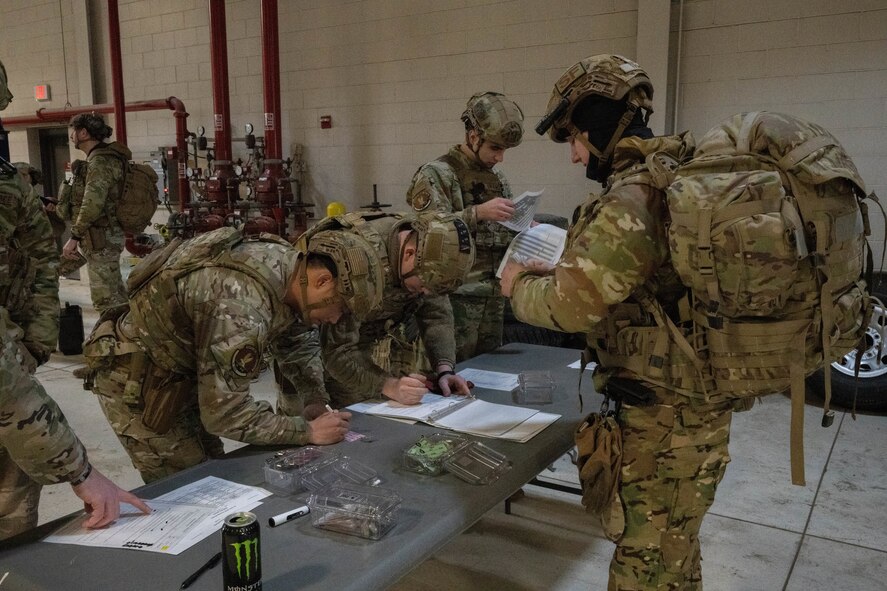 Airmen assigned to the 91st Missile Security Forces Squadron clear other defenders for the exercise to ensure they are ready to depart for a Missile Alert Facility (MAF) at Minot Air Force Base, North Dakota, Jan. 14, 2025. The exercise requires Airmen to go through a thorough clearing process in preparation of a simulated assault on a MAF. (U.S. Air Force photo by Airman 1st Class Wesley Davies)
