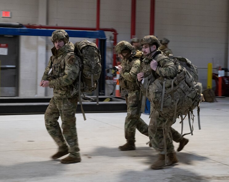 Airmen assigned to the 91st Missile Security Forces Squadron run to the armory to gather their gear as part of an exercise at Minot Air Force Base, North Dakota, Jan. 14, 2025. The simulated assault exercise is very fast paced and requires its participants to move quickly when able to, providing support to the Missile Alert Facility as efficiently as possible. (U.S. Air Force photo by Airman 1st Class Wesley Davies)