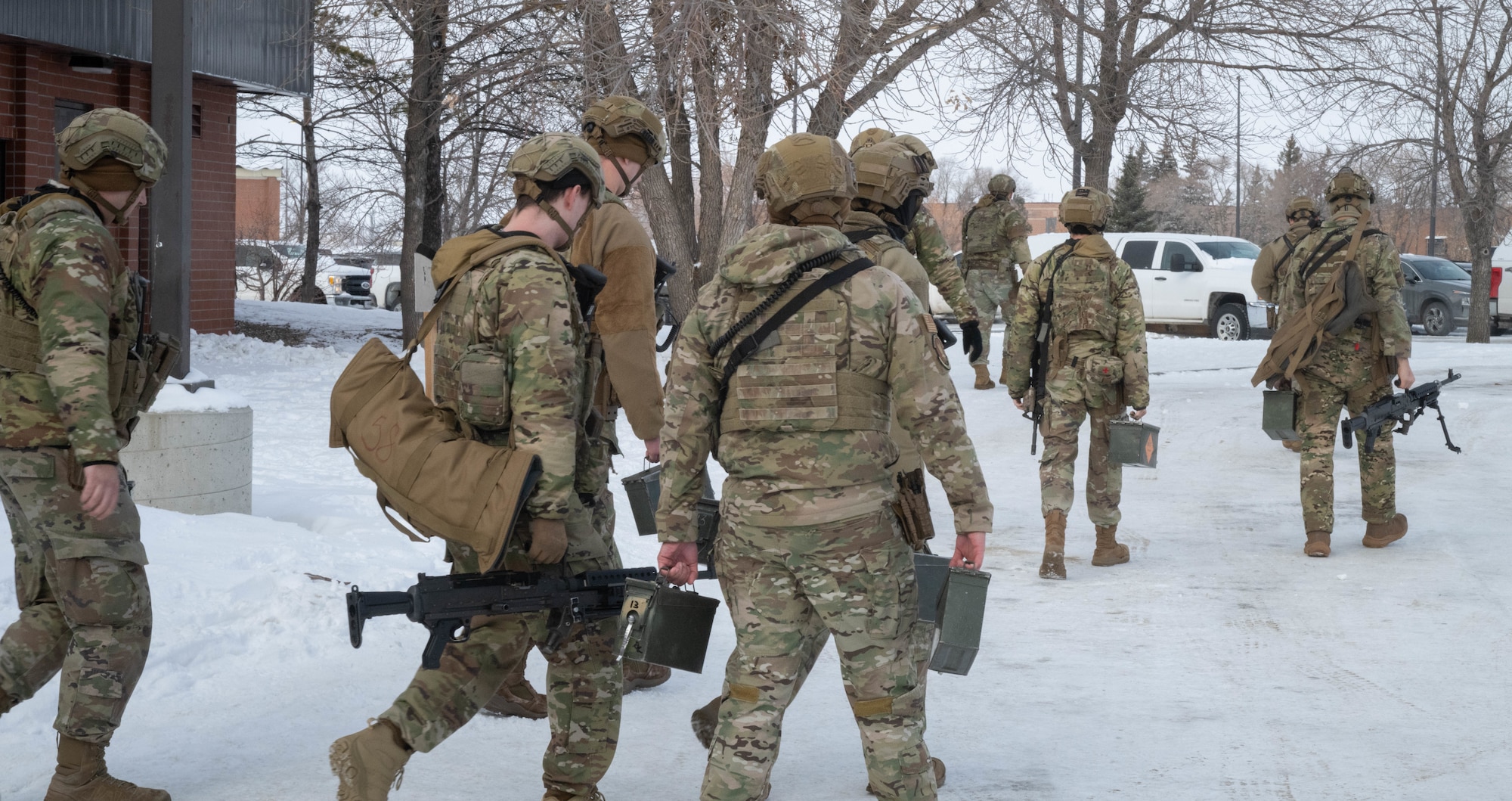 Airmen assigned to the 91st Missile Security Forces Squadron carry their gear to trucks en route to a Missile Alert Facility (MAF) during an exercise at Minot Air Force Base, North Dakota, Jan. 14, 2025. The Airmen that are a part of the exercise must be fully ready to help resolve the simulated assault on the MAF effectively. (U.S. Air Force photo by Airman 1st Class Wesley Davies)