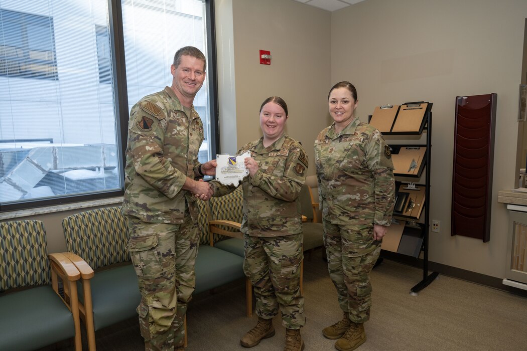 Col. Dustin Richards, 88th Air Base Wing and Installation Commander, Chief, Chief Master Sgt. Tessa Fontaine, 88 ABW command chief, celebrate SrA Rikki Arnold for winning Amn of the Quarter for the third quarter Jan. 15, 2024, Wright-Patterson Air Force Base, Ohio.