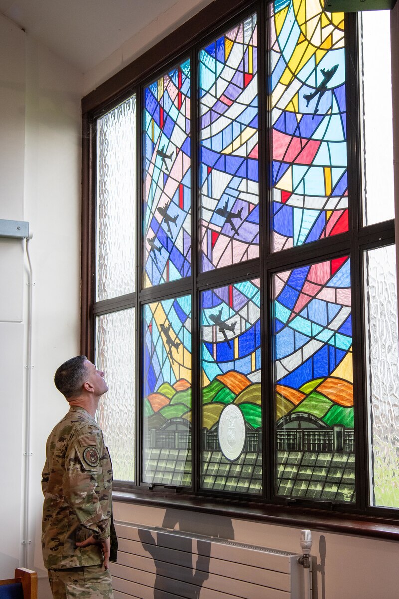 The Air Force Chief of Chaplains admires a stained glass scene in a Chapel window