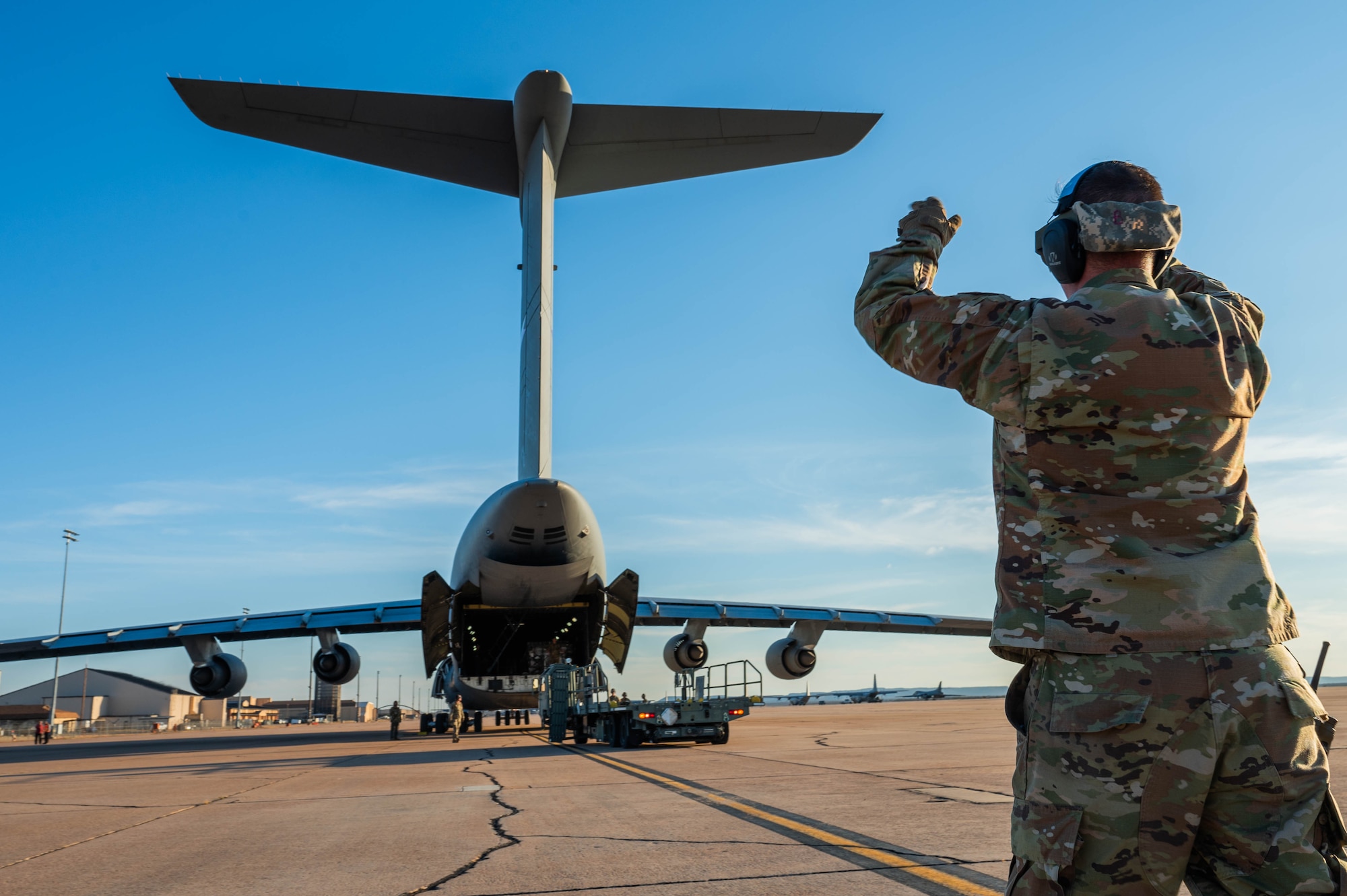 U.S. Air Force Tech Sgt. Eric Hazlewood, 7th Logistics Readiness Squadron air transportation function supervisor, directs an empty loader after loading humanitarian cargo into a C-5M Super Galaxy from the 68th Airlift Squadron, Joint-Base San Antonio-Lackland, Texas, at Dyess Air Force Base, Texas, Jan. 16, 2025. The 7th LRS staged 35,730 pounds of rice to transport to Honduras and El Salvador for humanitarian aid, providing commodities directly to families who struggle with food insecurity. (U.S. Air Force photo by Senior Airman Alondra Cristobal Hernandez)