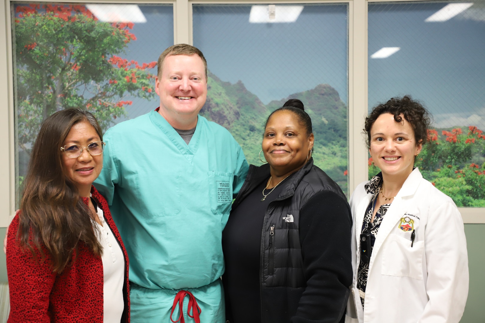 U.S. Army Lt. Col. David Anderson, center left, gynecologic oncologist at Tripler Army Medical Center, is working to raise awareness about cervical cancer during National Cervical Cancer Awareness Month. Anderson poses with coworkers Rowena McCartney, a registered nurse; Lisa Lowe, a registered nurse; and Jamie Humes, a staff physician on on Jan. 17, 2025. (Defense Health Agency photo by Khinna Kaminske)