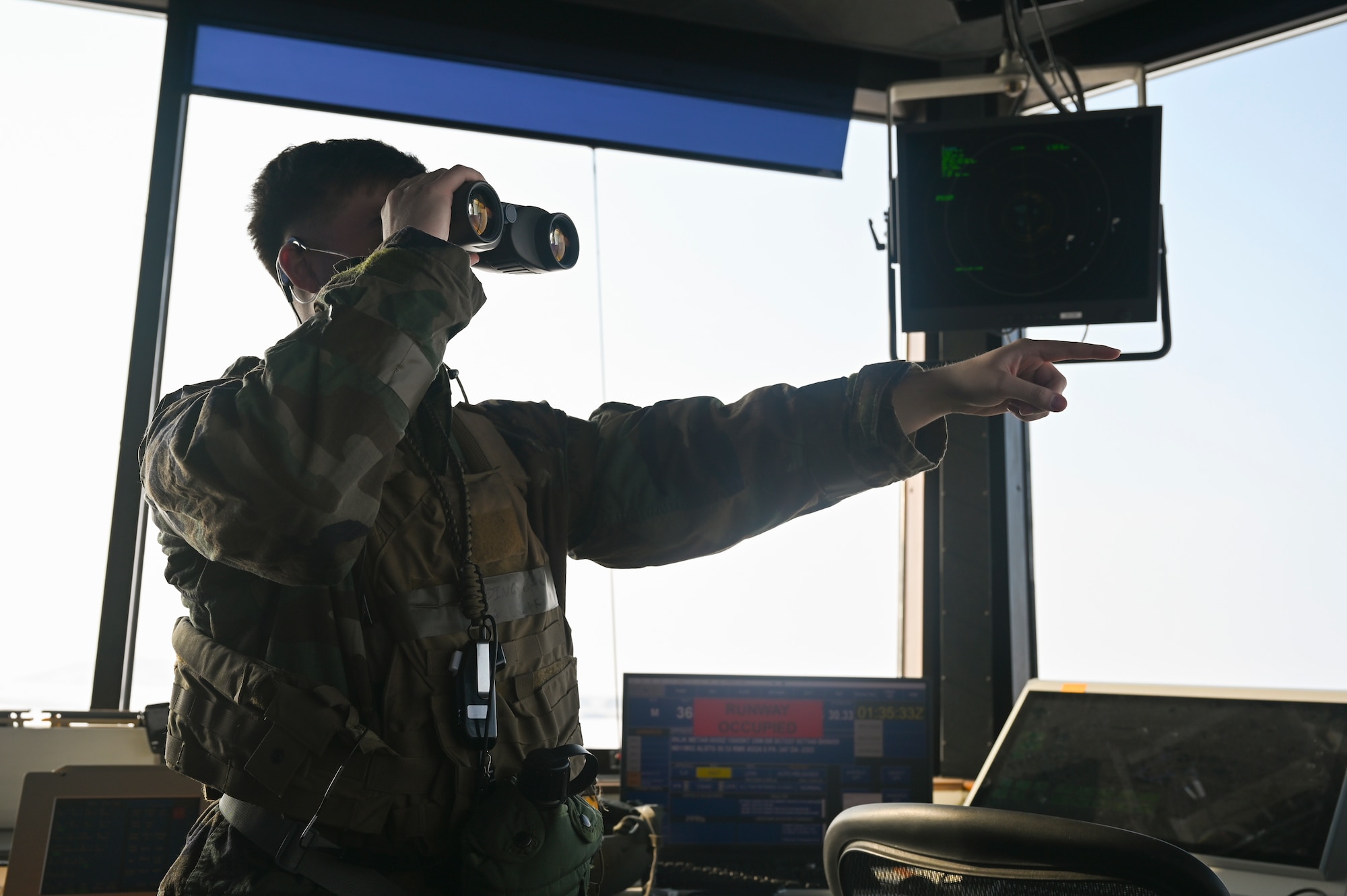 Senior Airman Calvin Redding, 8th Operations Support Squadron air traffic control tower trainer, looks through a set of binoculars to oversee airfield operations during Beverly Pack 25-1.