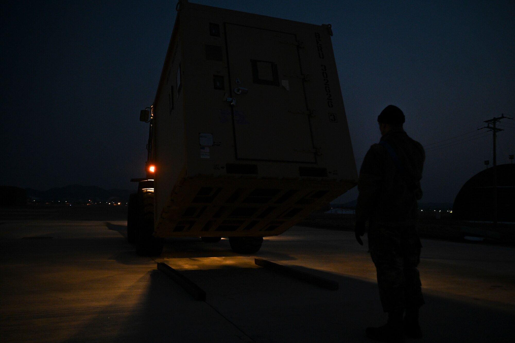 Airman 1st Class Hayden Tyler, 35th Fighter Generation Squadron crew chief, marshals a forklift carrying a military cargo container from Kunsan Air Base for Beverly Pack 25-1 at Gwangju Air Base, Republic of Korea, Jan. 12, 2025.