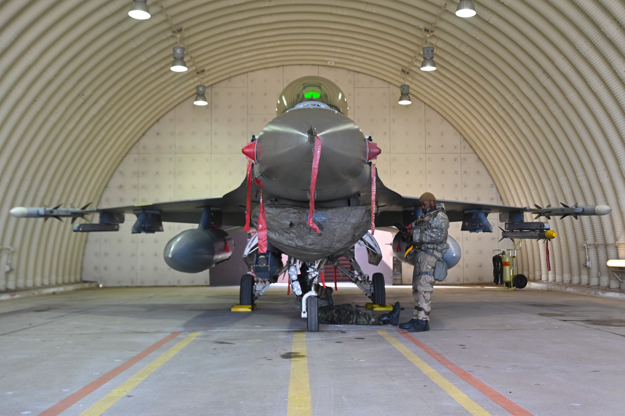 Airman 1st Class Quatavious Cash, 35th Fighter Generation Squadron assistant dedicated crew chief, reads a pneumatic servicing job maintenance technical order, while U.S. Air Force Staff Sgt. Elvis Atieno, 35th FGS dedicated crew chief, performs the order during exercise Beverly Pack 25-1 at Gwangju Air Base, Republic of Korea, Jan. 14, 2025.