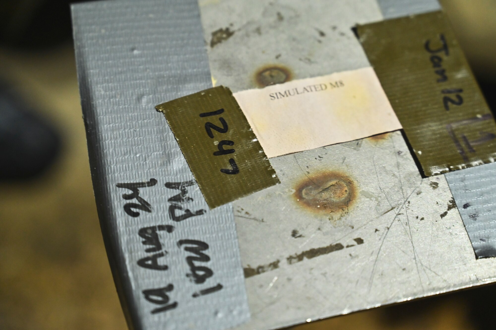Simulated M8 chemical detection paper is displayed on a pedestal.