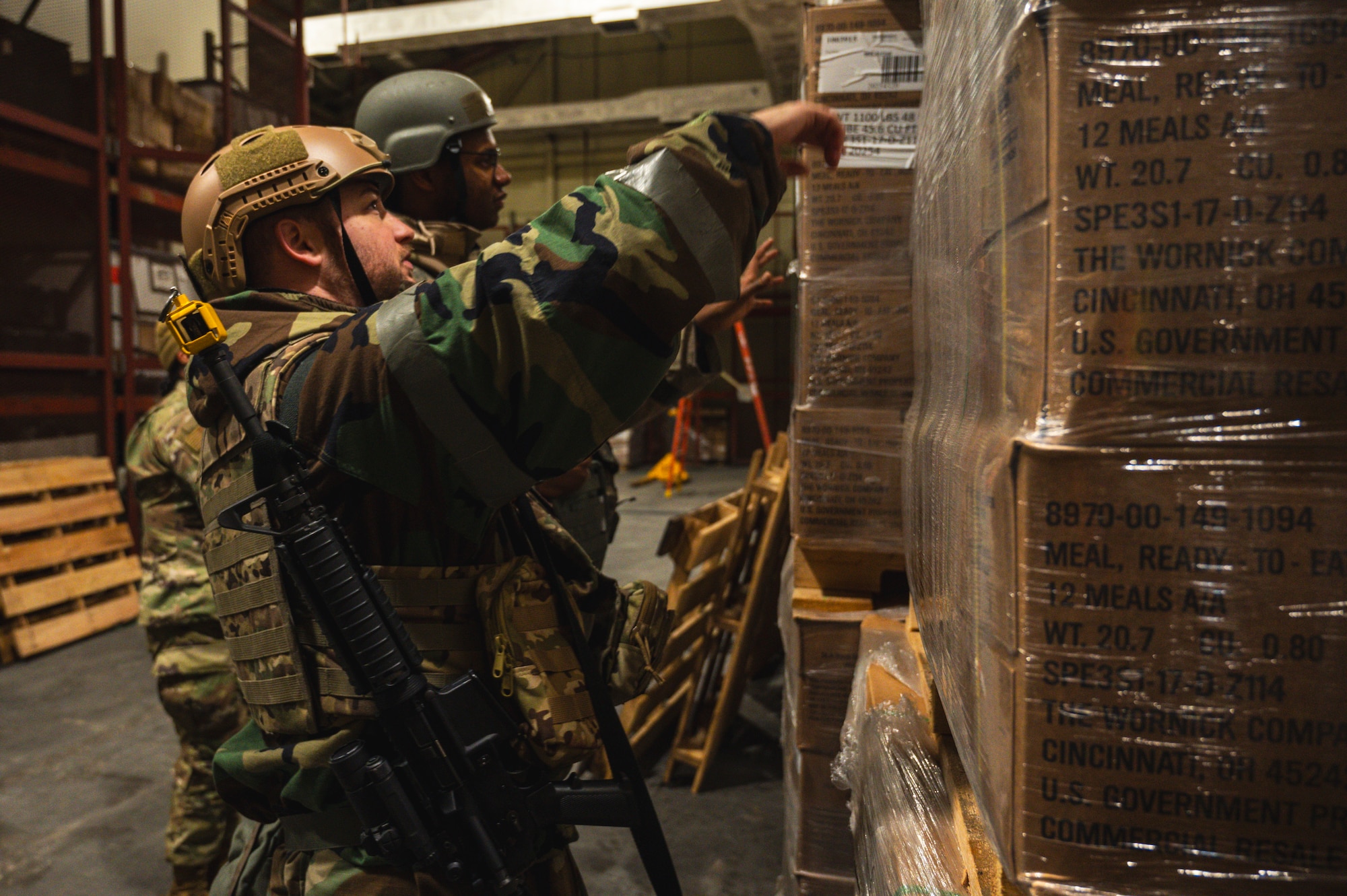 U.S. Air Force Staff Sgt. Jared Mitchell, 8th Operational Medical Readiness Squadron dental technician, and Senior Airman Jaylen Green, 8th OMRS dental technician, inspect meal ready-to-eat pallets for contaminants after a simulated air attack.