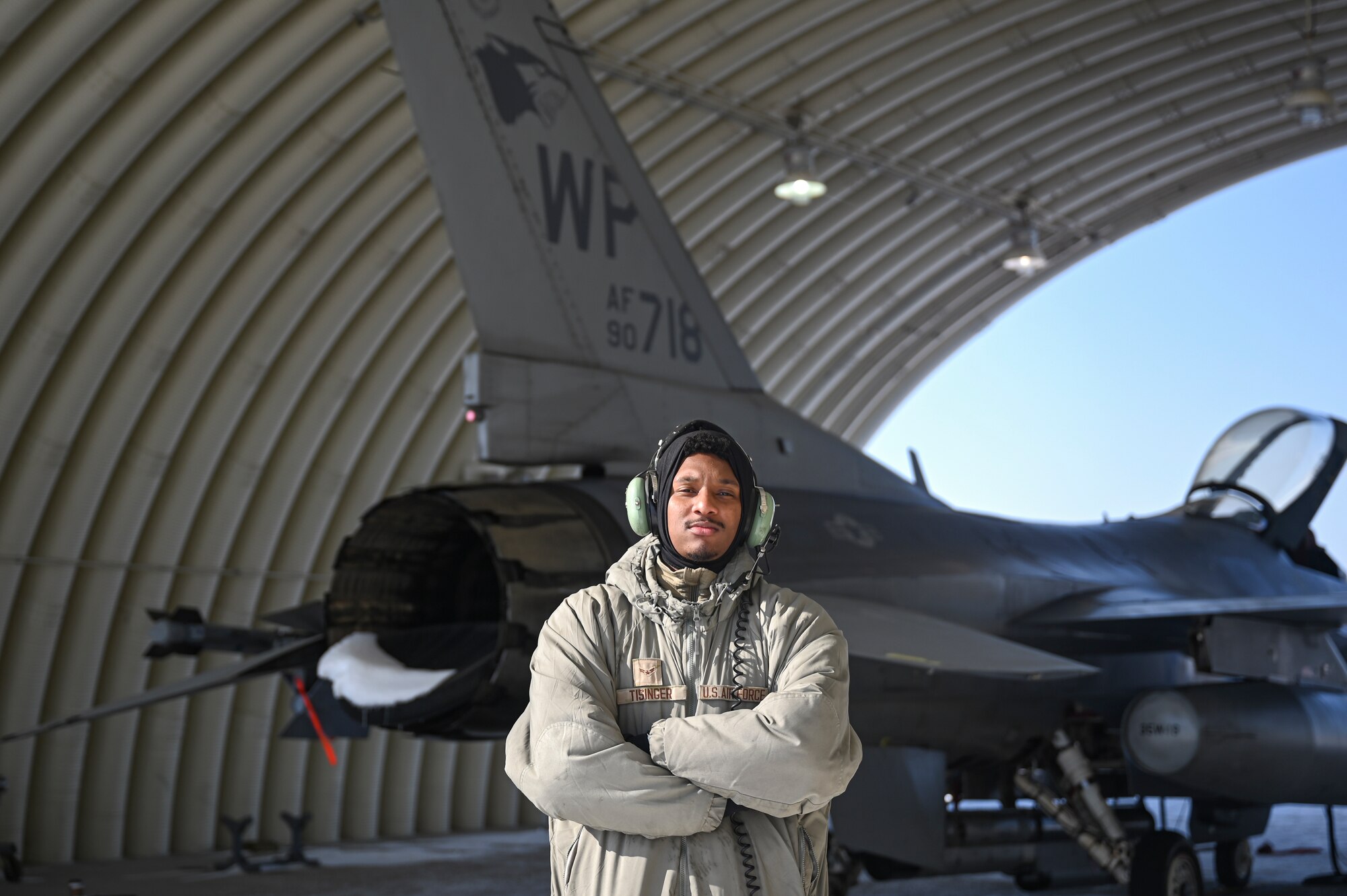 Airman 1st Class Jachonn Tisinger, 35th Fighter Squadron weapons load member, poses in front of an F-16 Fighting Falcon aircraft.