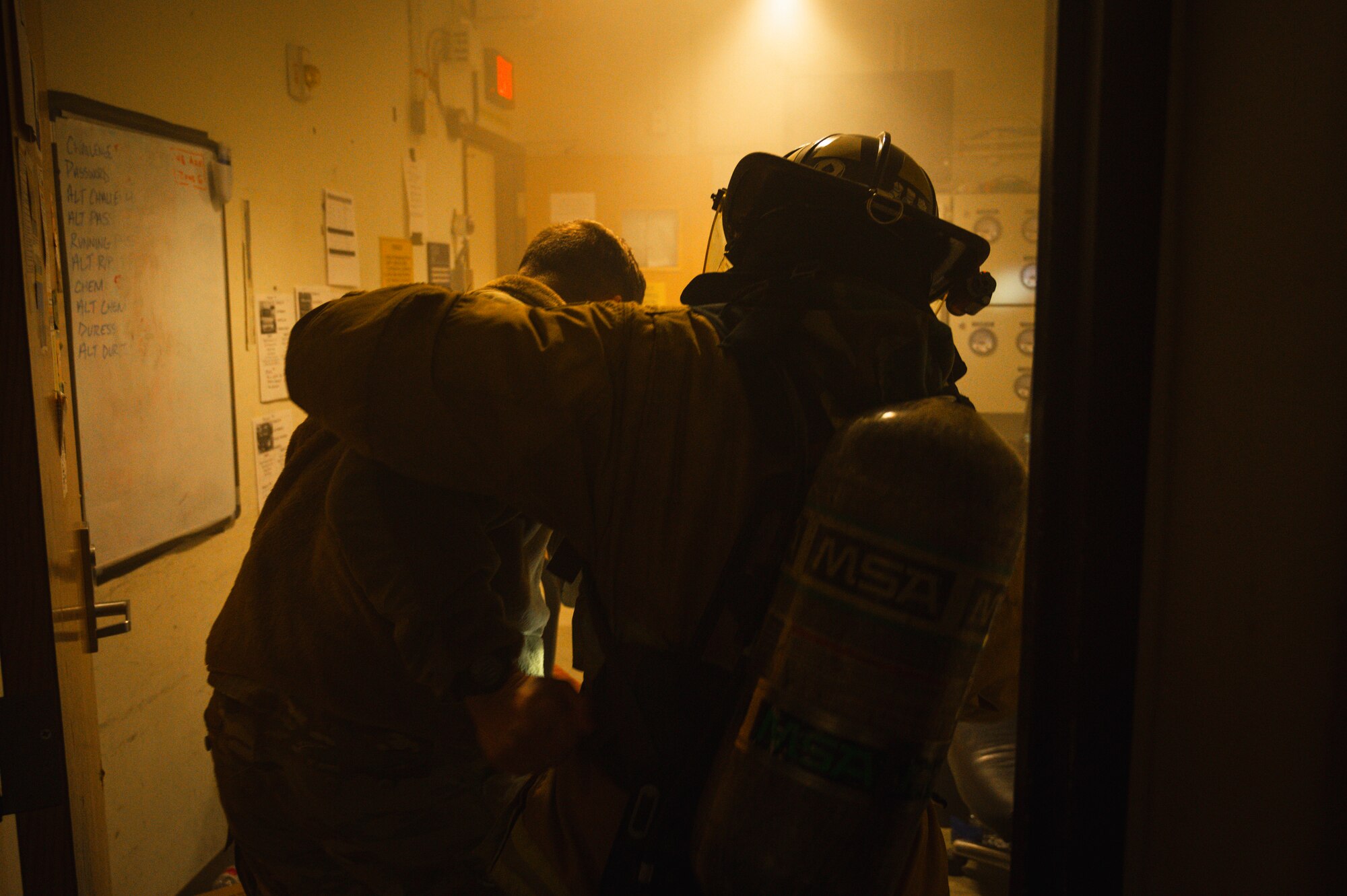 U.S. Air Force Staff Sgt. Jahryd Hopkins, 8th Civil Engineering Squadron lead firefighter, escorts Senior Airman Brandon Benson, 8th Communications Squadron technician, radio operations, out of a simulated fire.