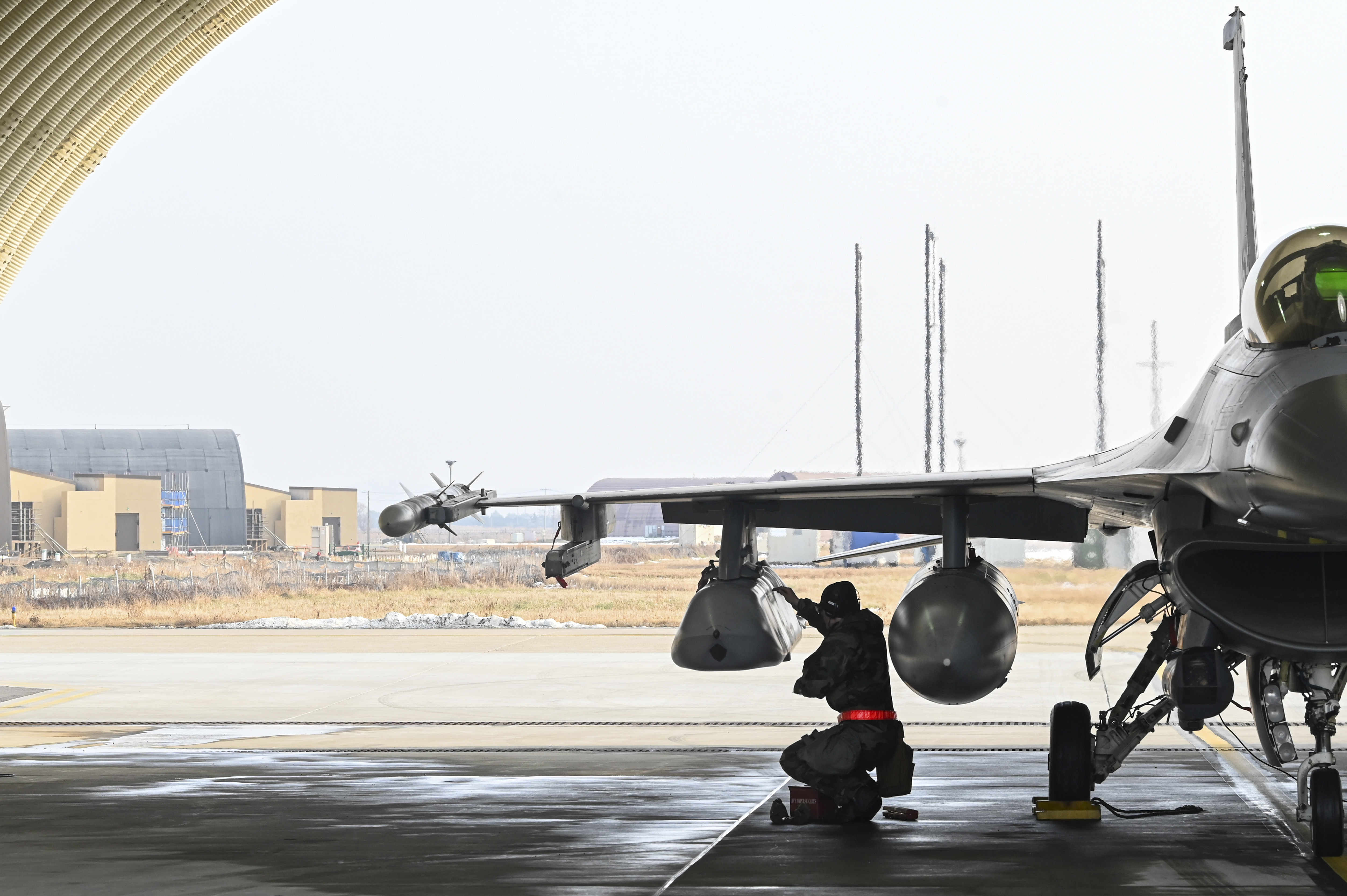 U.S. Air Force Staff Sgt. Joshua Denice, 35th Fighter Generation Squadron loads a Joint Air-to-Surface Standoff Missile on an F-16 Fighting Falcon aircraft during Beverly Pack 25-1 at Kunsan Air Base, Republic of Korea, Jan. 14, 2025. The 8th Maintenance Group executed Kunsan's first integrated combat turn with a JASSM, loading the munition and refueling the aircraft while it was still running. An ICT is the act of rearming a jet while it is running to ensure quick turnover and return to operations; a key capability for rapidly projecting airpower. (U.S. Air Force photo by Senior Airman Maria Umanzor Guzman)