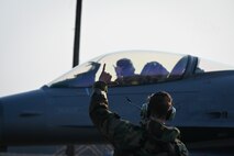 Airman 1st Class Layne Veldhuizen, 35th Fighter Generation Squadron assistant dedicated crew chief, sends the unit motto designation “Push It Up” to U.S. Air Force Capt. Tom Marron, 35th Fighter Squadron F-16 Fighting Falcon pilot, prior to taxiing at Gwangju Air Base during Exercise Beverly Pack 25-1, Republic of Korea, Jan. 14, 2025.