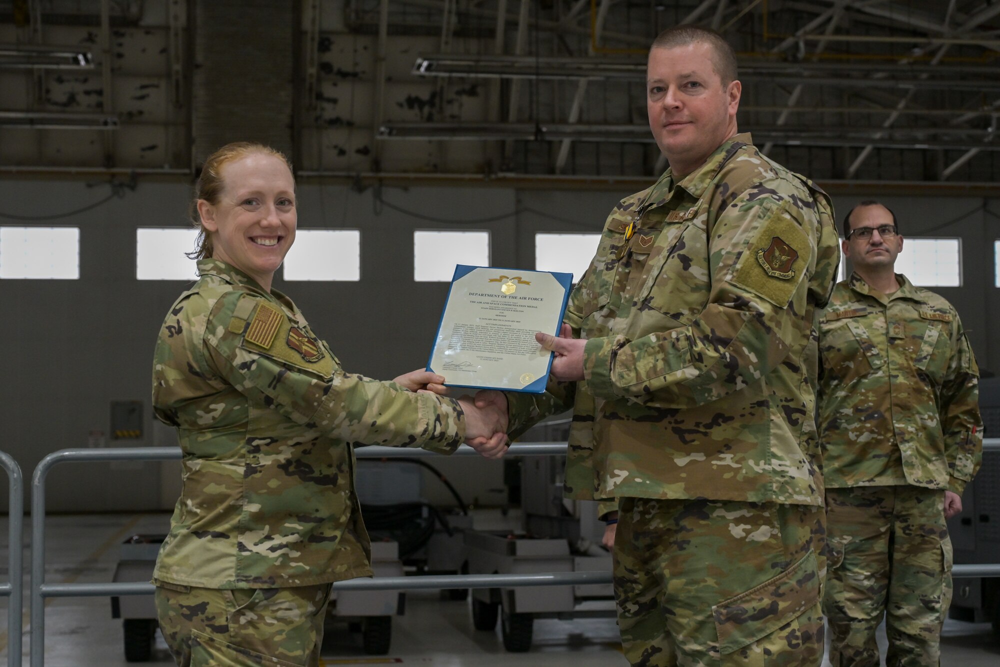 Commander (left) poses with Airman who received decoration