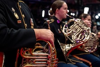 A close up of a Soldier holding their instrument in their lap