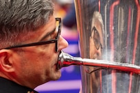 close up of tuba player playing with his reflection on the tuba