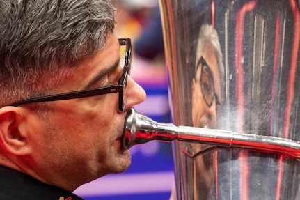 close up of tuba player playing with his reflection on the tuba
