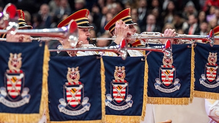 Trumpet players performing with banners on their instruments