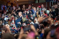 President trump walking between crowd of parade attendees