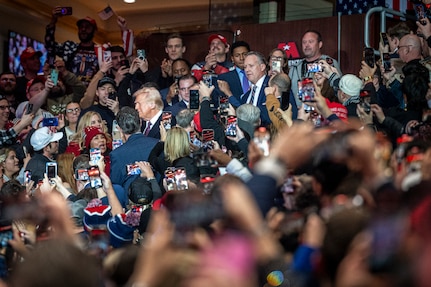 President trump walking between crowd of parade attendees